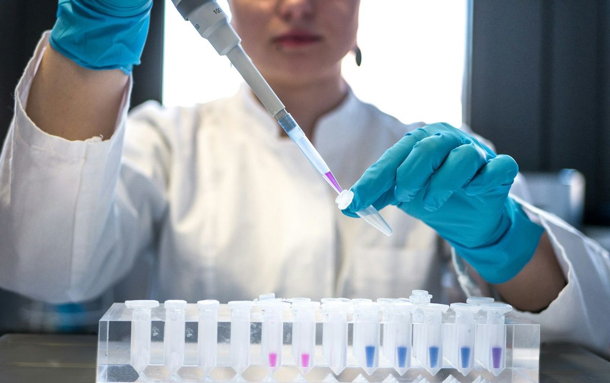 Laboratoriemedarbeider bruker pipette over prøverør på benken