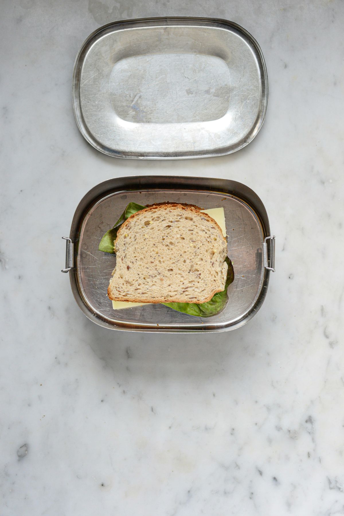 Matpakke med smørbrød pakket i en matboks av metall